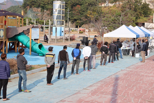 외국인 노동자들이 고성군 맥전포항에 설치된 임시선별검사소에서 진단검사를 받기 위해 줄지어 있다. 고성군